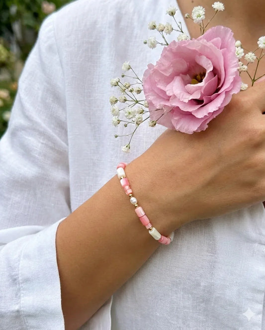 צמיד חרוזים ורודים ולבנים עם פנינה עגולה על פרק כף היד