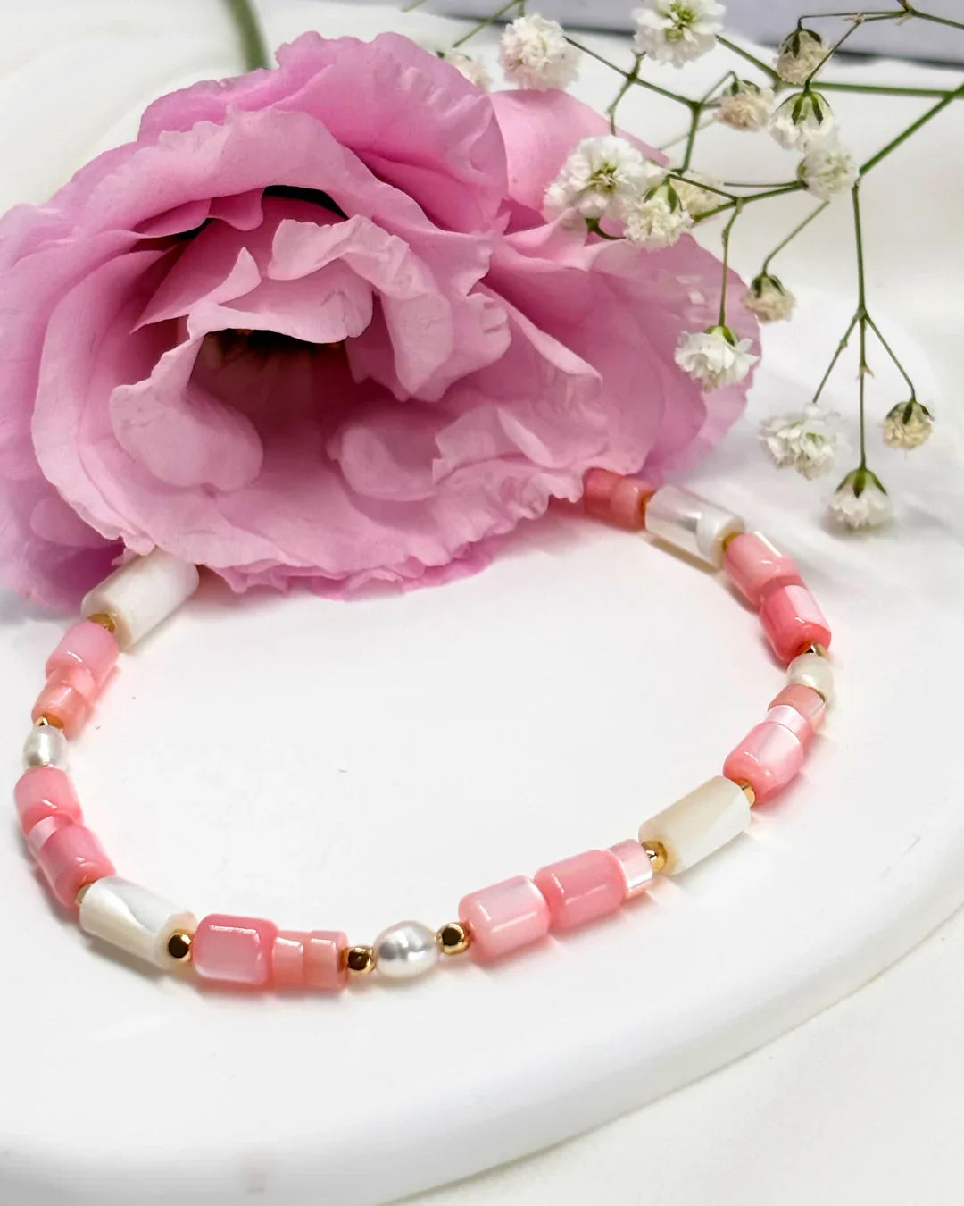 צמיד חרוזים ורודים ולבנים עם חרוזי פנינה וזהב בעיצוב עדין ויפהפה