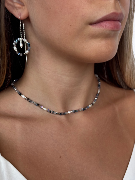 עגיל תלוי עשוי כסף 925 או כסף בציפוי זהב עם תליון עגול של חרוזי זכוכית, פנינים וחרוזיים מלבניים בציפוי כסף או זהב עם תליון מרכזי של פנינה מתנדנדת.